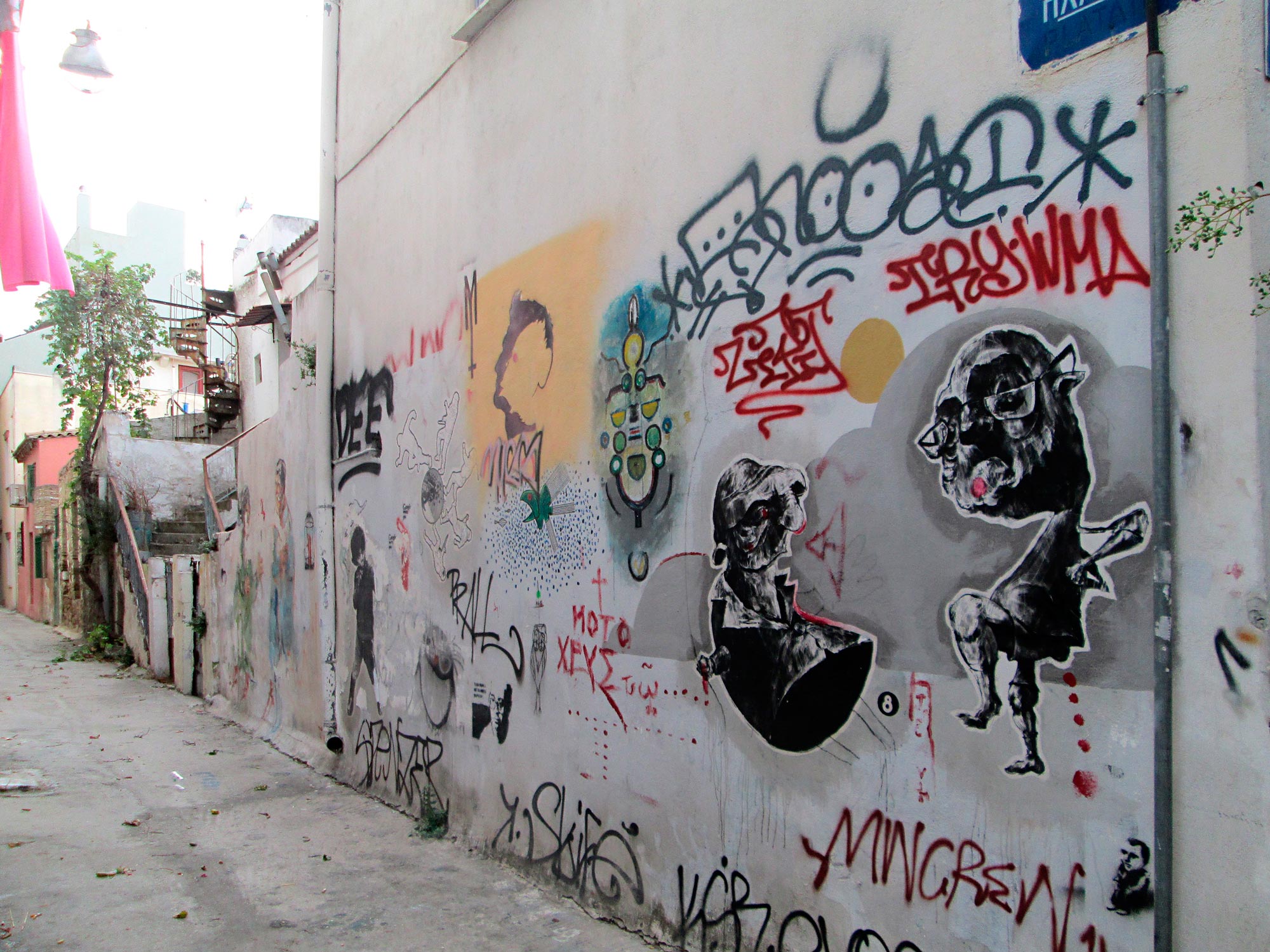 Eine Seitenstraße in Athen, die das chaotische nebeneinander von Graffiti und Streetart spiegelt